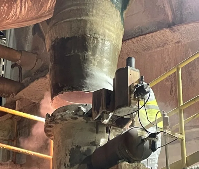 A worker cleans a pipe using a specialized tool